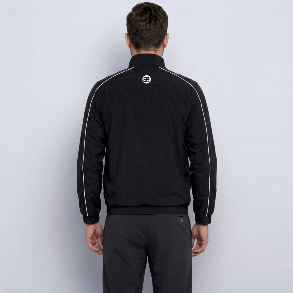 Person wearing a black tracksuit with a logo on the back against a white background