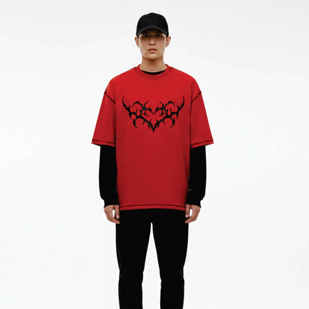 Person wearing a red t-shirt with black tribal design on a white background