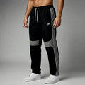 Black and gray track pants with white accents on a gray background