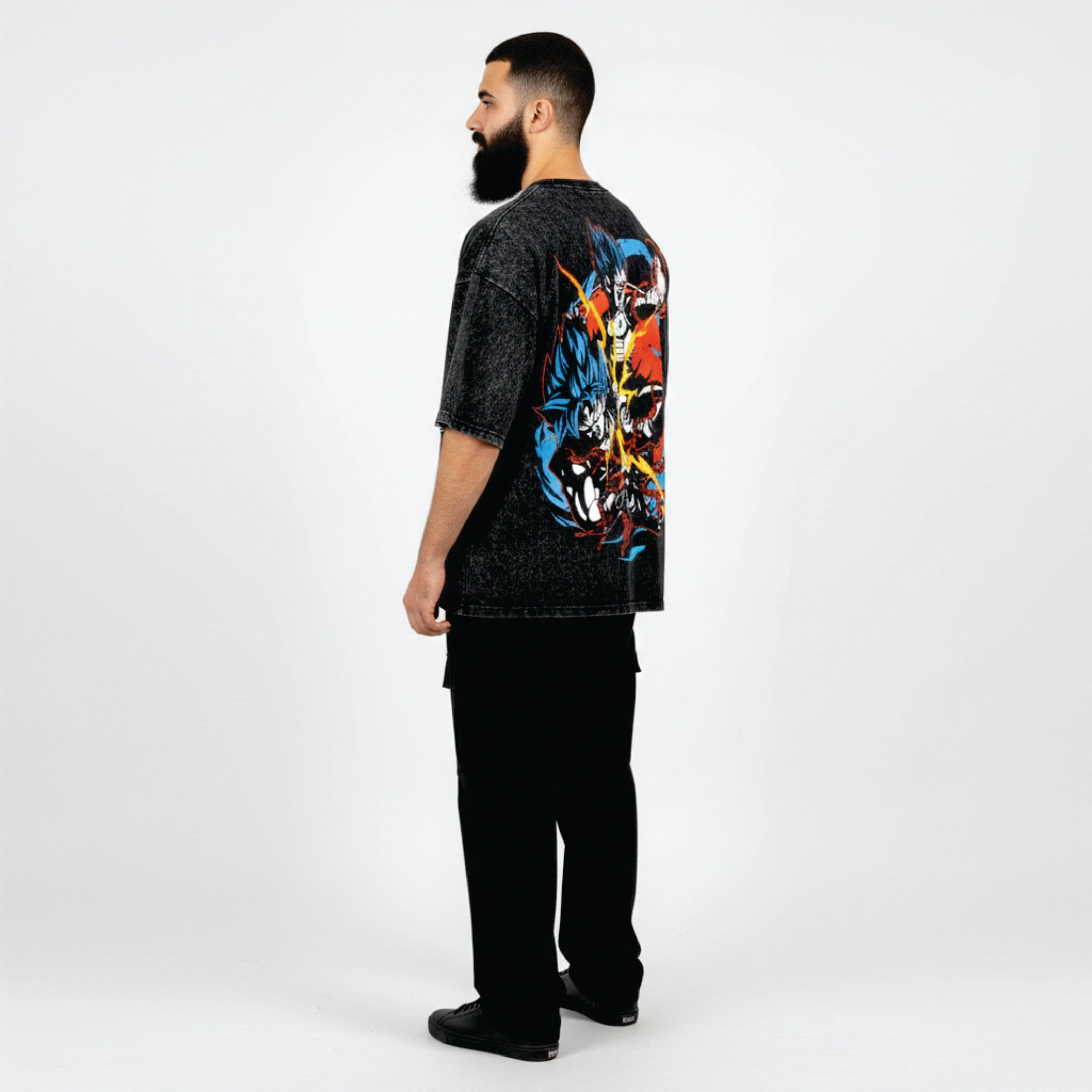 Man wearing a black t-shirt with colorful graphic design on the back, standing against a white background
