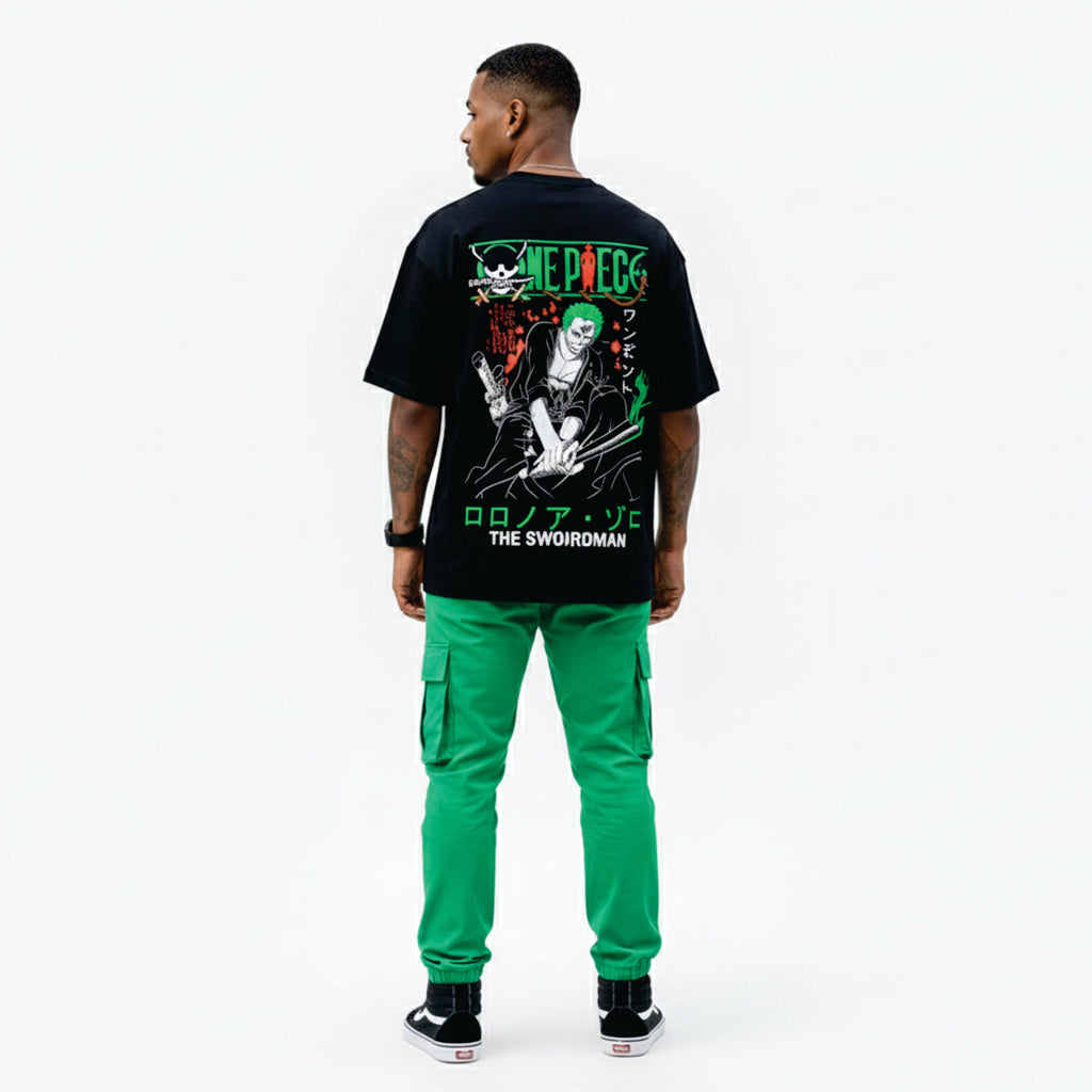 Person wearing a black t-shirt with graphic design and green pants on a white background