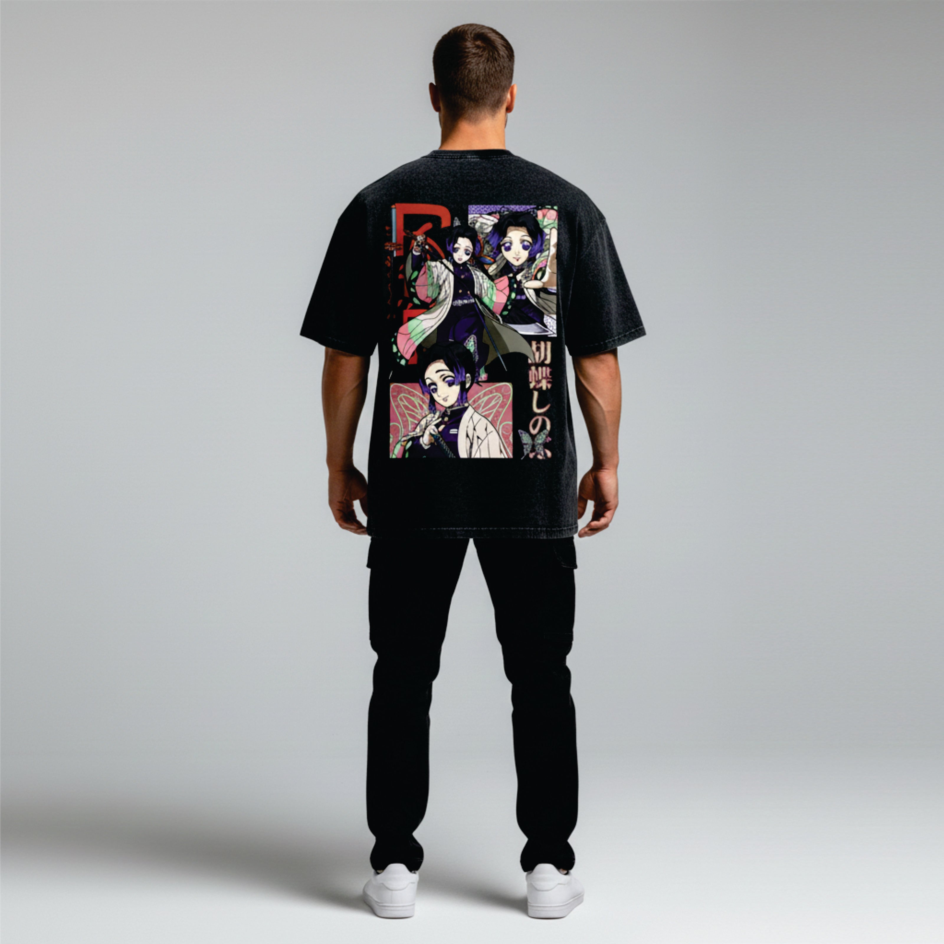 Person wearing a black t-shirt with colorful graphic design on the back against a light gray background