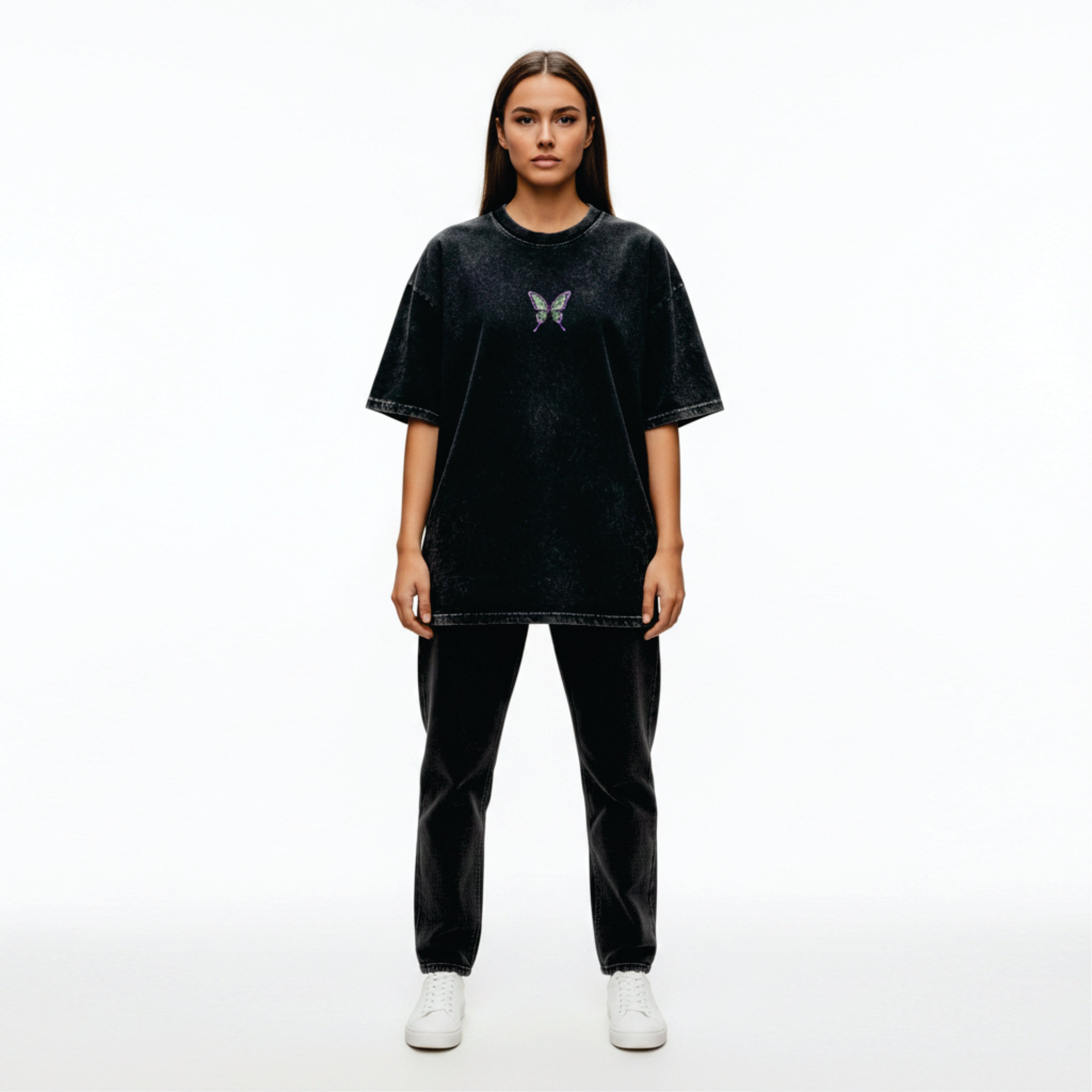 Person wearing a black oversized t-shirt with a butterfly design on a white background
