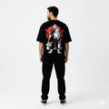 Person wearing a black t-shirt with a graphic design on the back, standing against a white background