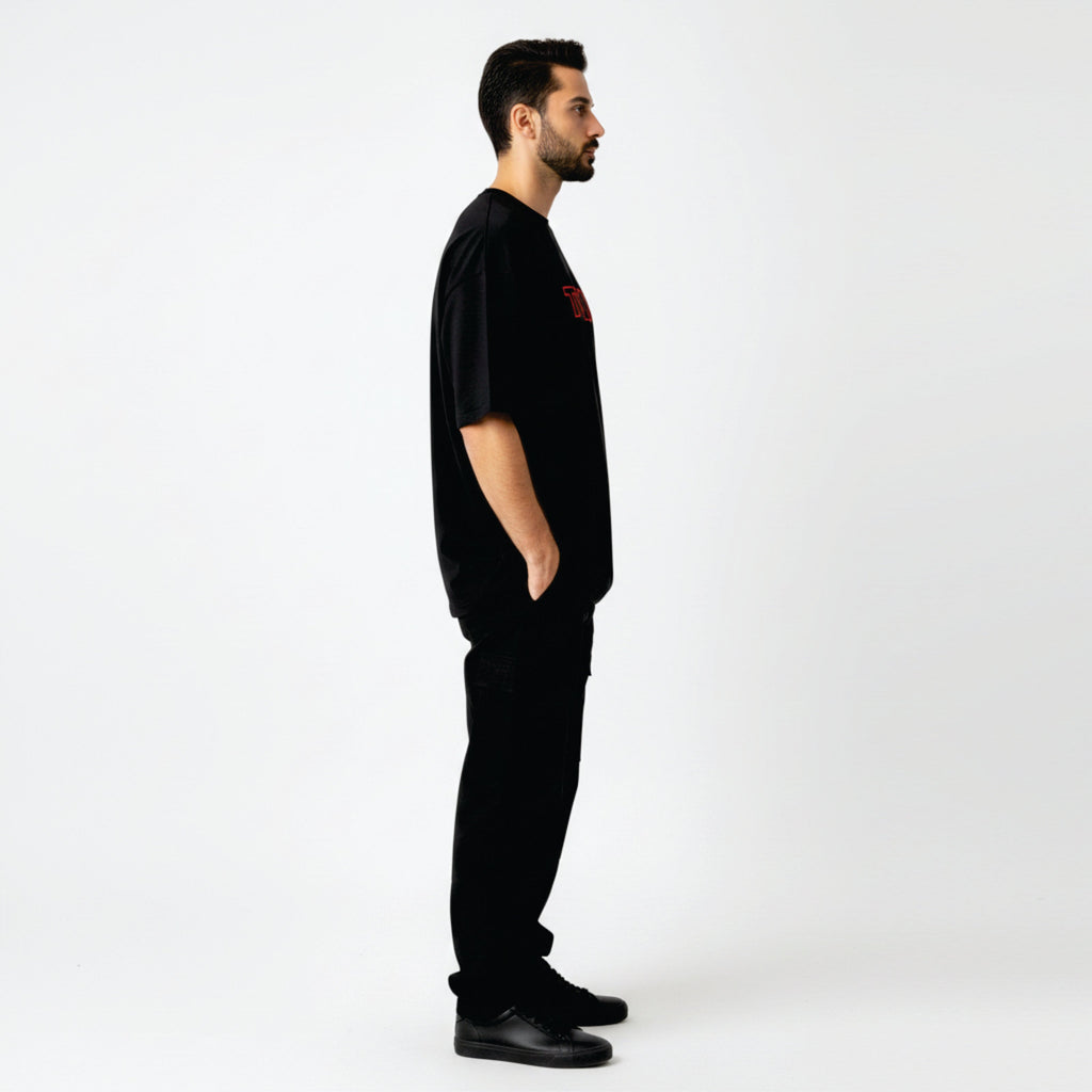 Man wearing a black t-shirt with a red logo on a white background