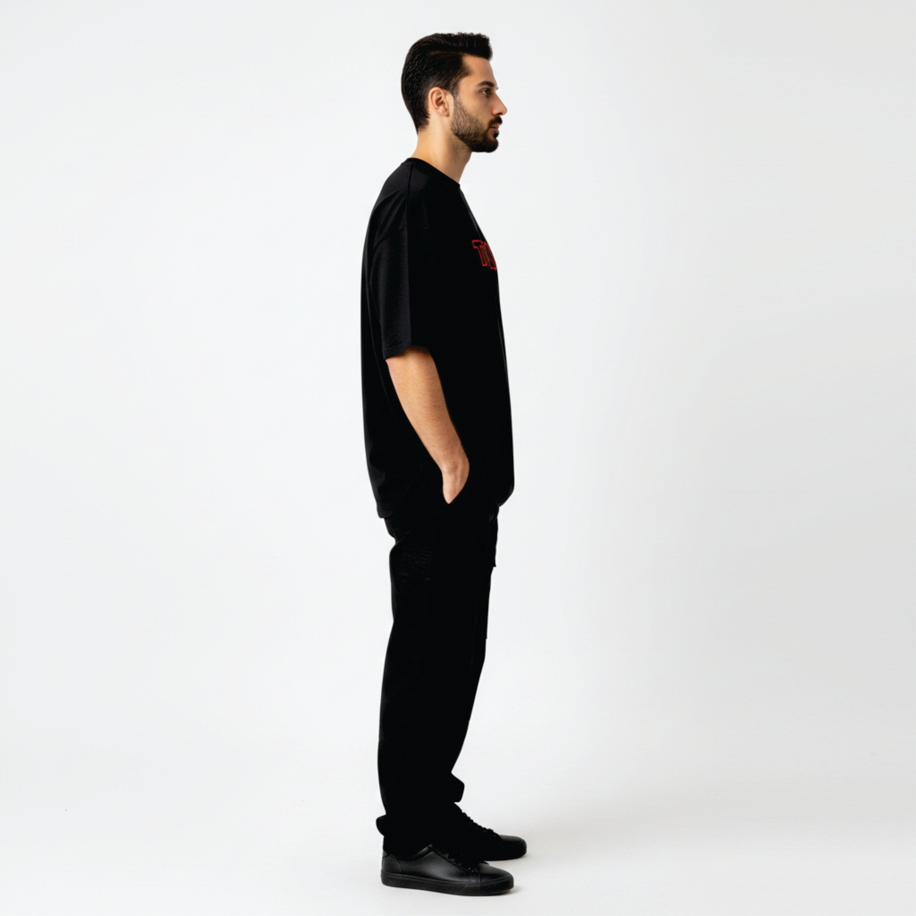 Man wearing a black t-shirt with a red logo on a white background