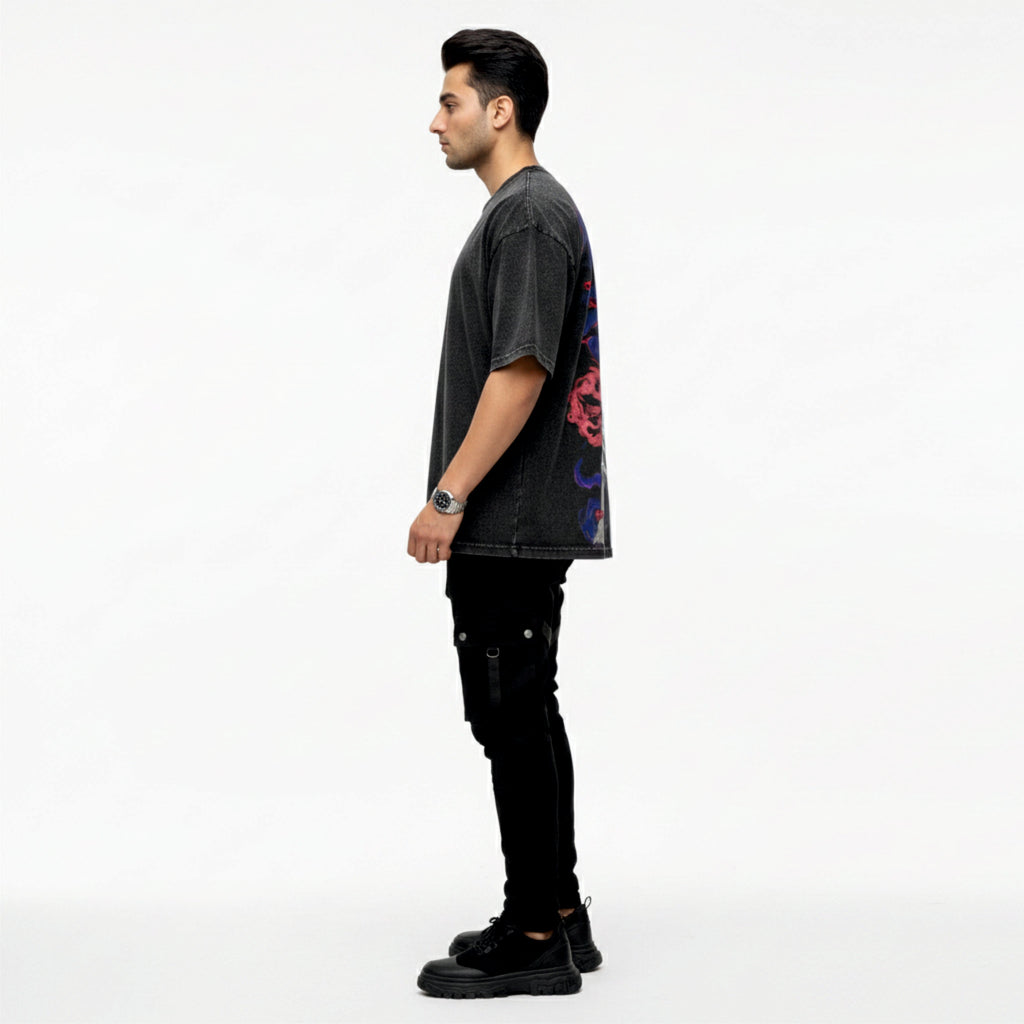 Man wearing a dark gray t-shirt with colorful designs on a white background