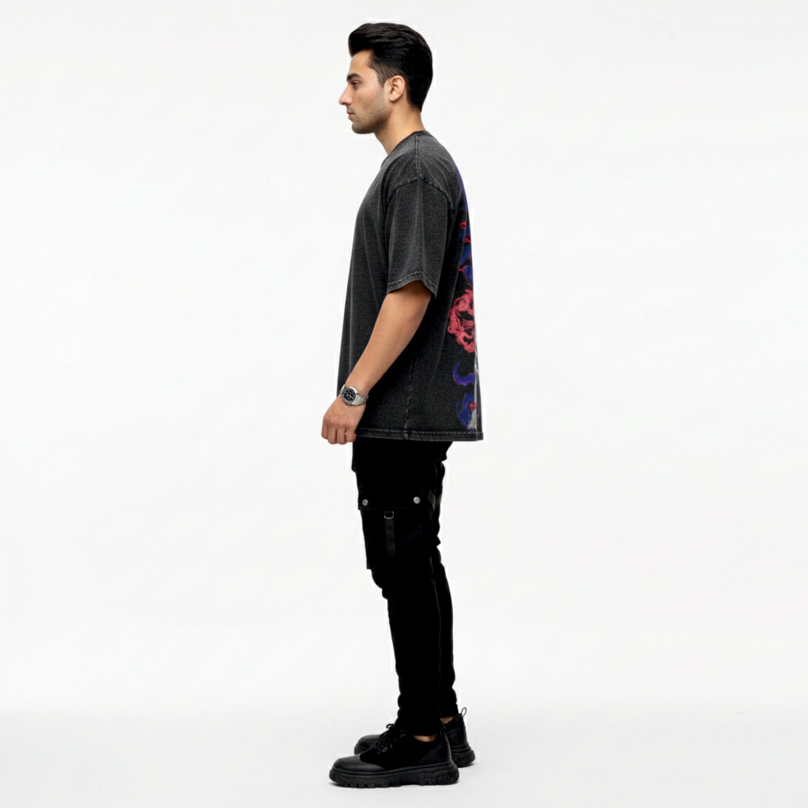 Man wearing a dark gray t-shirt with colorful designs on a white background