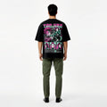 Person wearing a black t-shirt with colorful graphics on the back, standing against a white background