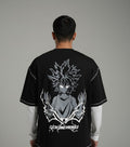 Person wearing a black t-shirt with a graphic design on the back against a gray background